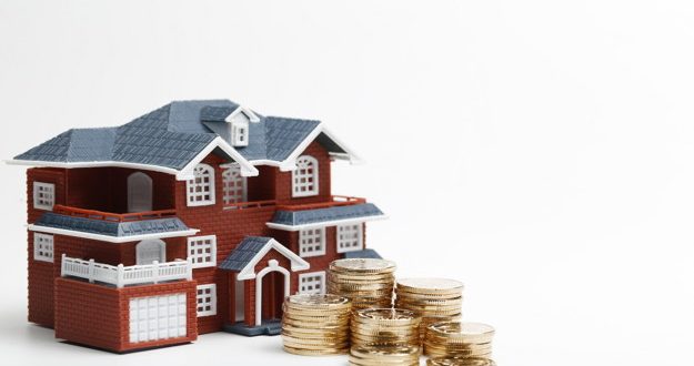 RMB coins stacked in front of the housing model (house prices, house buying, real estate, mortgage concept)
