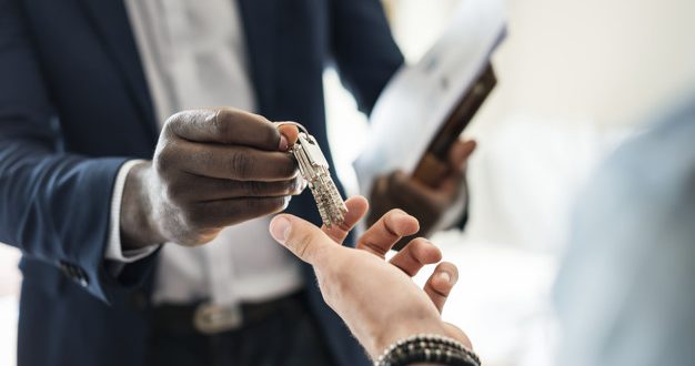 Real estate agent handing the house key to a client