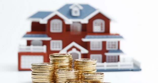 RMB coins stacked in front of the housing model (house prices, house buying, real estate, mortgage concept)