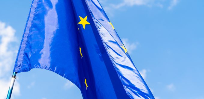 European Union flag against blue sky waving