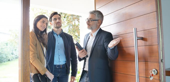 Couple with real-estate agent visiting modern house