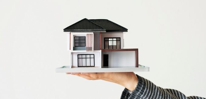 Hand presenting model house for home loan campaign